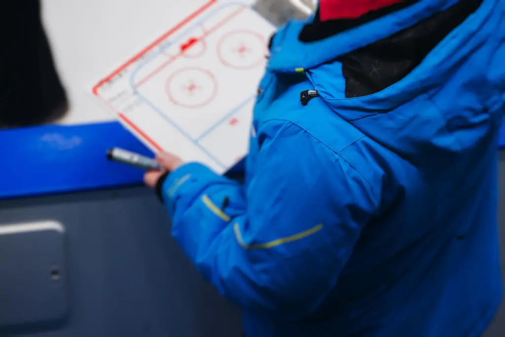 Hockey trainer reviewing playbook on ice rink